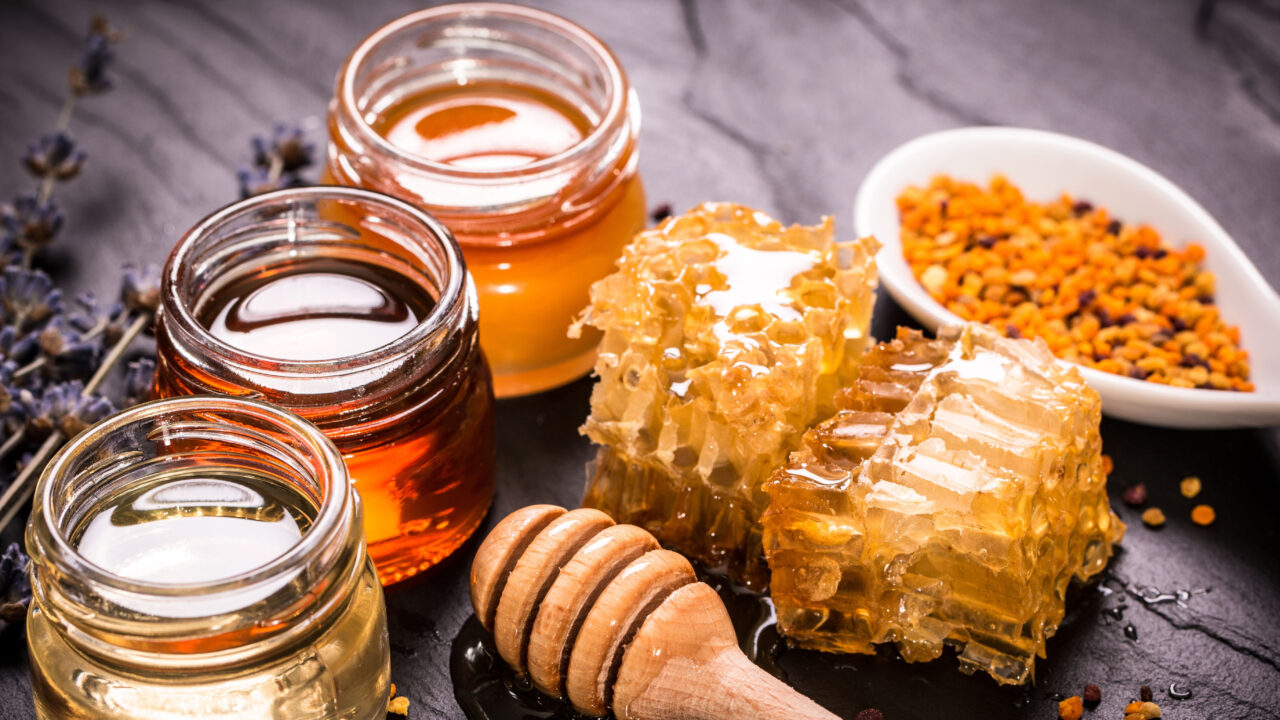 Jars of honey with dipper.