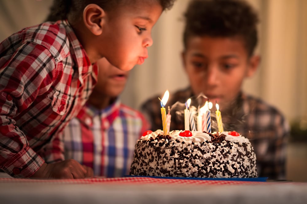 toddler blows out candles