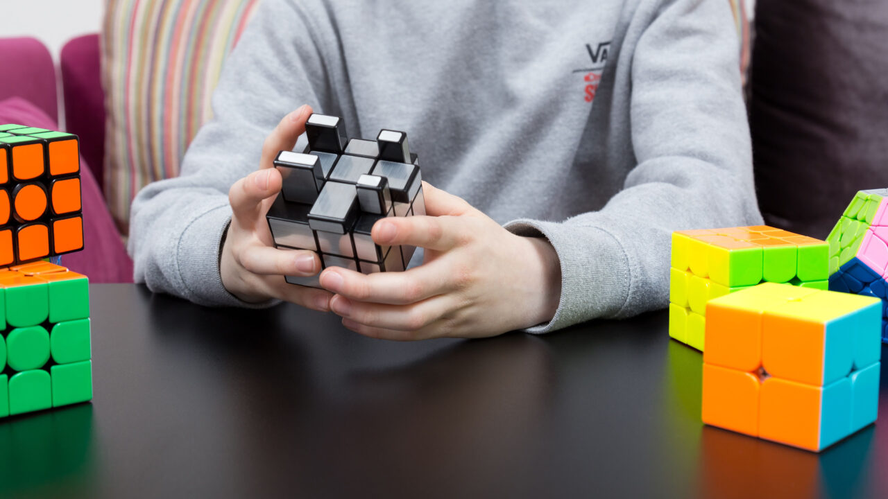 Teen with multiple rubics cubes.